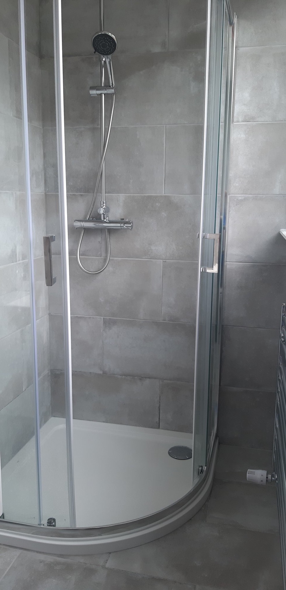 Shower enclosure with grey tiling