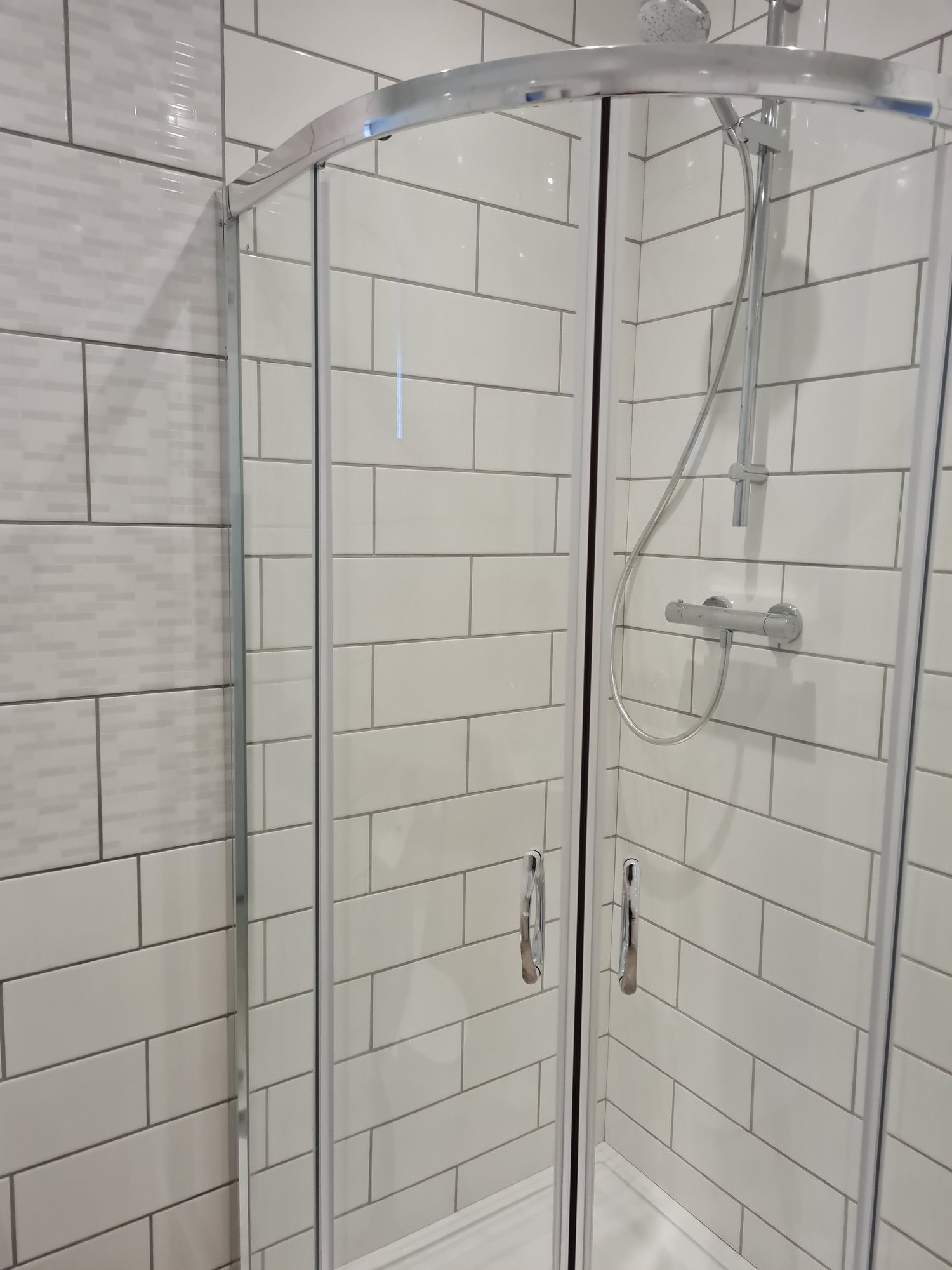 Curved shower enclosure with subway tiles