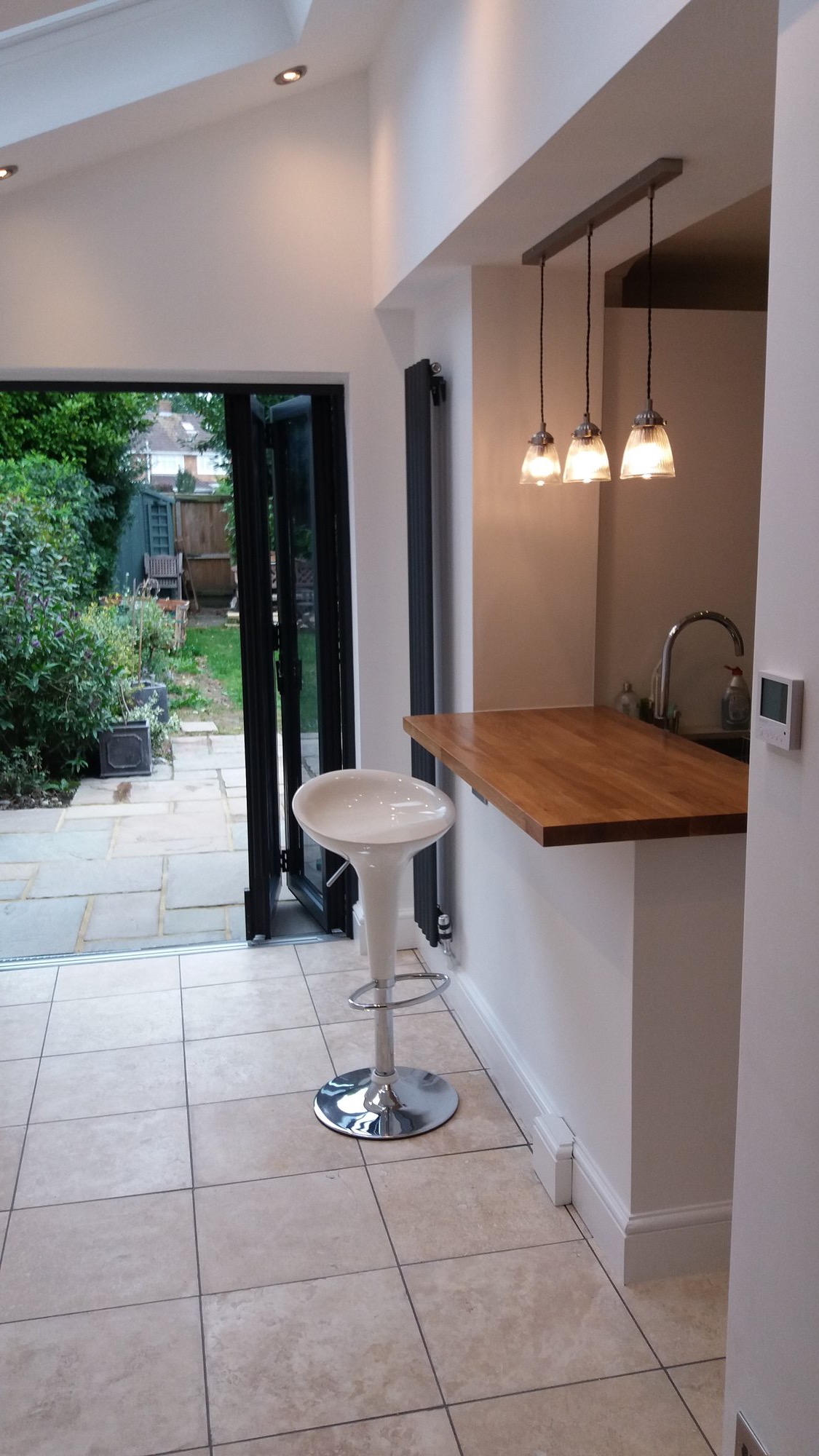 Open plan kitchen with oak breakfast bar and bifold doors